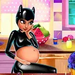 Μια έγκυος γυναίκα με μαύρη στολή και κεφαλόδεσμο-αυτιά γάτας κάθεται στην κουζίνα περιτριγυρισμένη από κεριά, λουλούδια και φρούτα