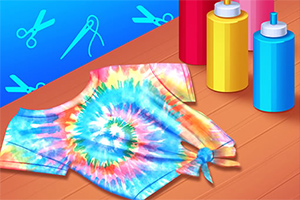 Πολύχρωμο βαμμένο μπλουζάκι τύπου tie-dye τοποθετημένο σε ξύλινη επιφάνεια, με μπουκάλια βαφής στο πλάι