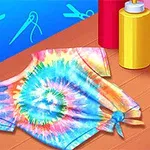 Πολύχρωμο βαμμένο μπλουζάκι τύπου tie-dye τοποθετημένο σε ξύλινη επιφάνεια, με μπουκάλια βαφής στο πλάι