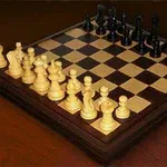 Σκακιέρα με κομμάτια τοποθετημένα για έναρξη παιχνιδιού πάνω σε ξύλινη επιφάνεια