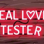 Φωτεινή επιγραφή νέον με τη φράση REAL LOVE TESTER πάνω σε ξύλινο φόντο